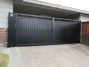 A black gate is open in front of a house